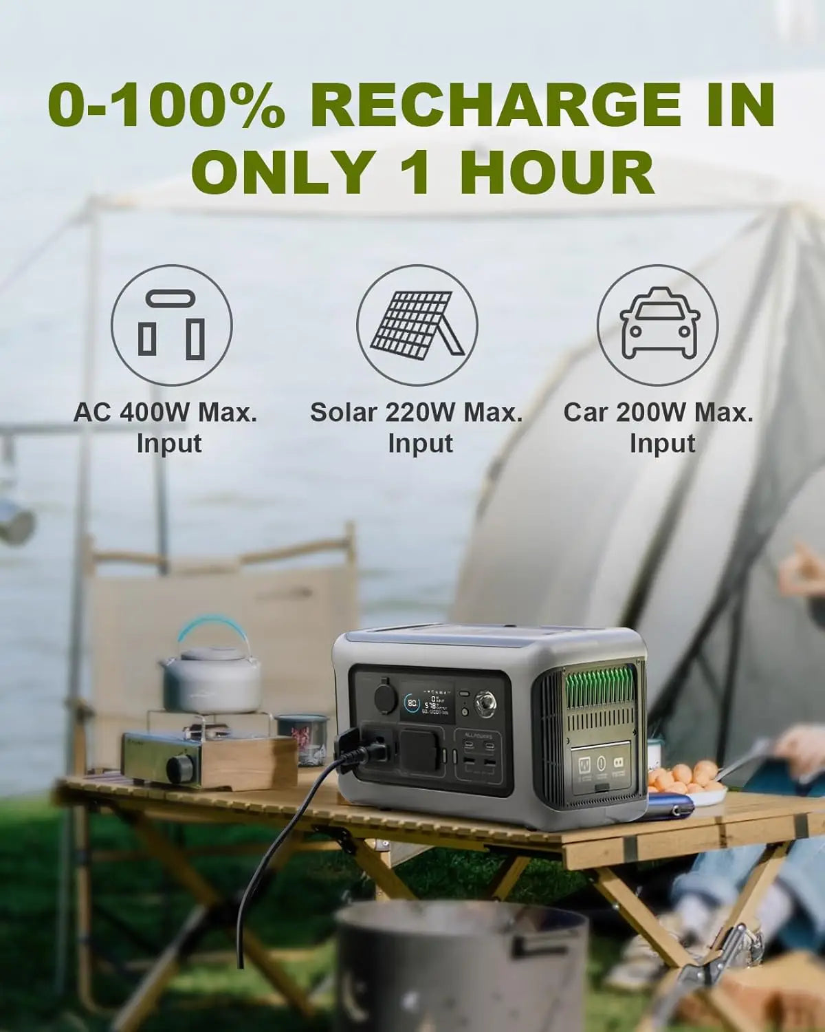 Portable power station on camping table with tent and cooking gear outdoors